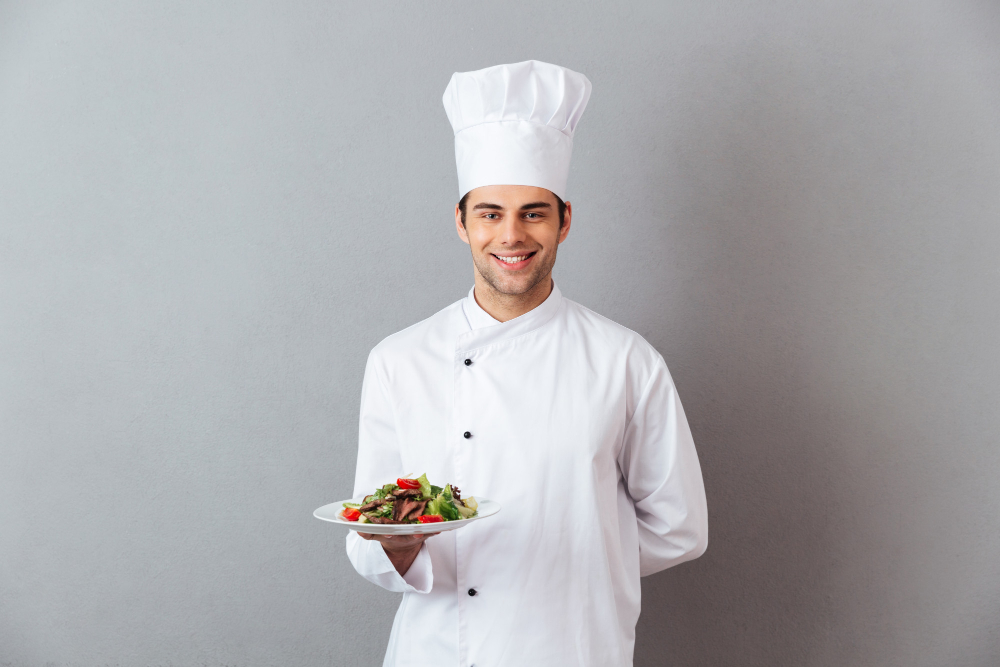 happy-young-cook-uniform-holding-salad